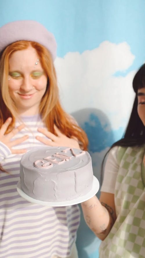 Young Women Dancing and Holding Cake