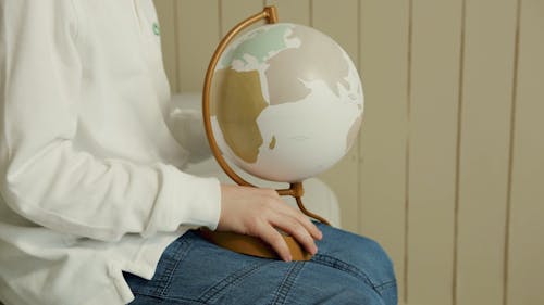 Person Rotating a Globe