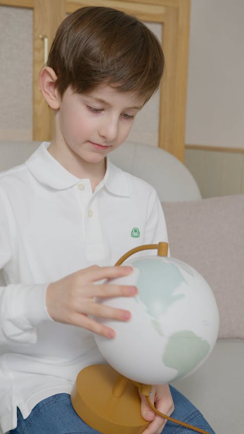 A Boy Holding a Rotating Global Map