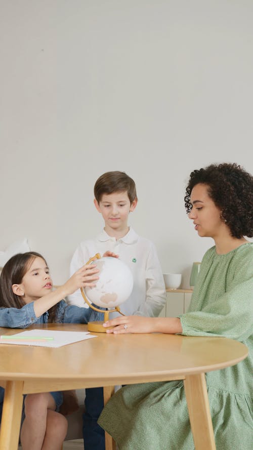 Female Teacher and Students Talking about a Globe