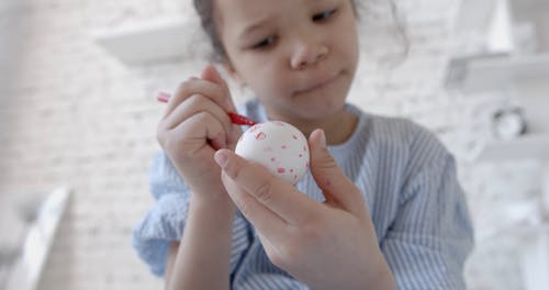 A Girl Drawing on an Egg