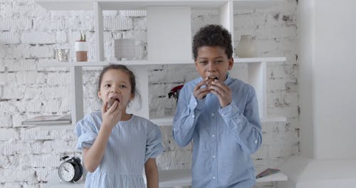 Siblings Eating Chocolate Eggs and Laughing