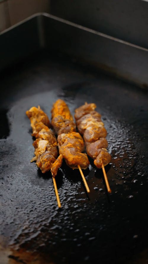 Close up Shot of a Skewer Cooking on a Flat Skillet