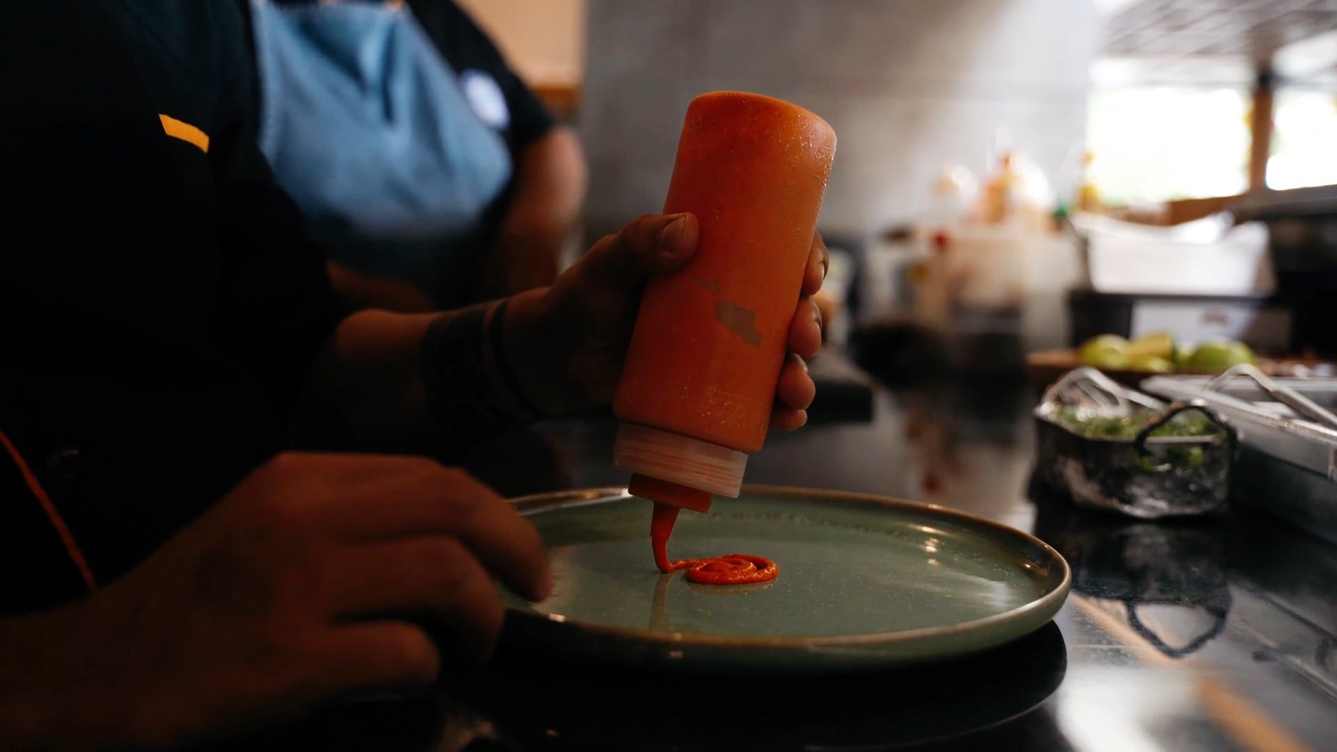 Chef finishing a plate with sauce