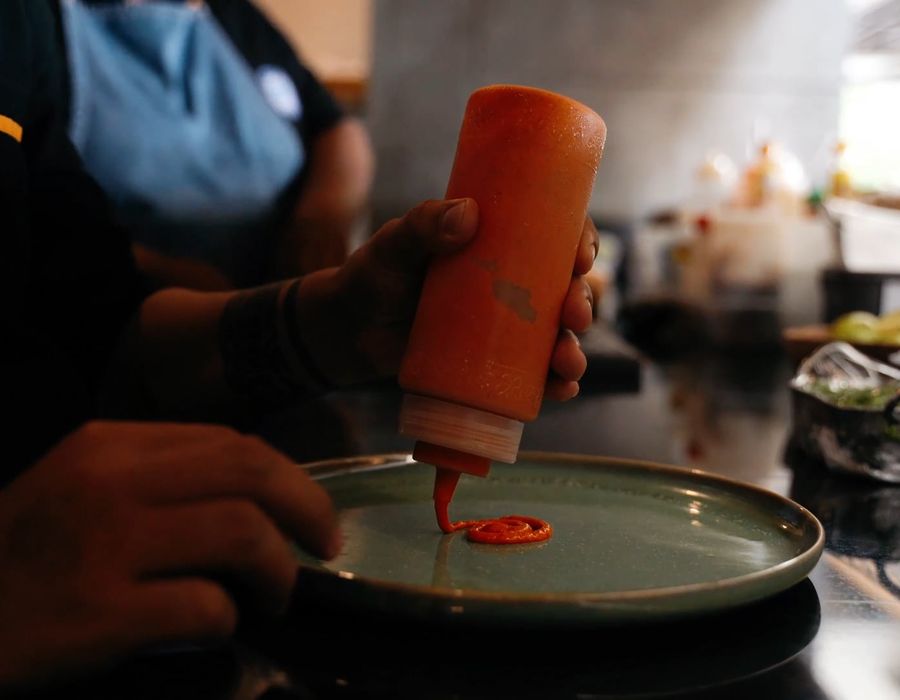 Chef finishing a plate with sauce
