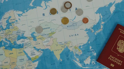 Close up Shot of a World Map with Passport on Top