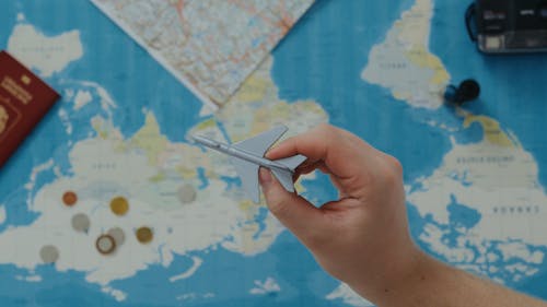 An Overhead Shot of a Toy Plane and a World Map