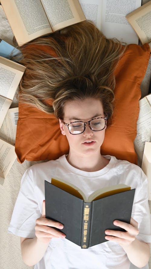 A Woman Reading Books while Lying Down