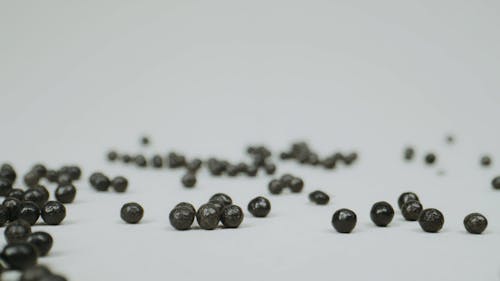 Dropping Black Balls on White Background