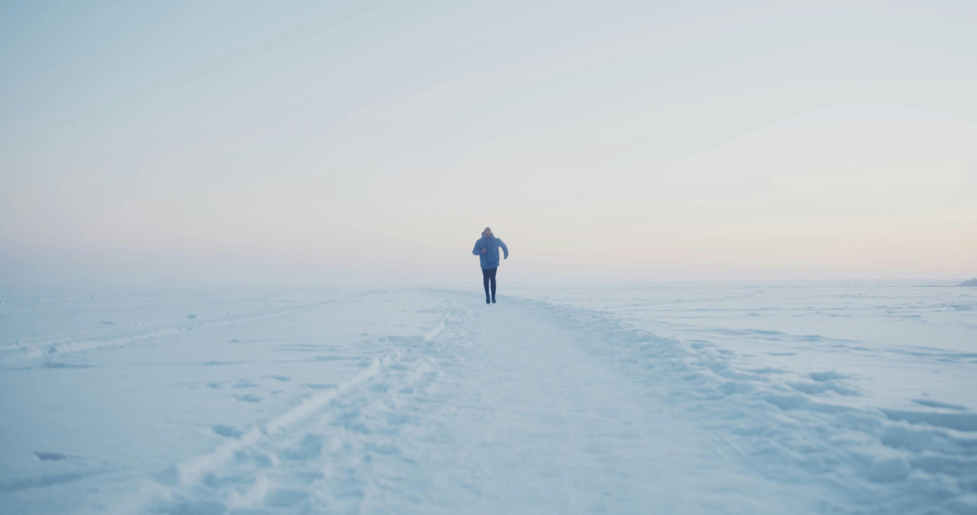 A Man Running on a Snowy Trail · Free Stock Video