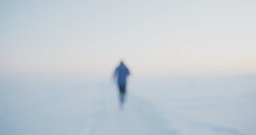 A Man Running on a Snowy Landscape