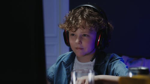 Boy Playing Computer Games while Eating Chips