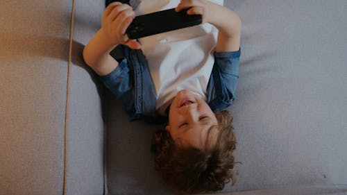 Video of a Boy Playing on a Cellphone