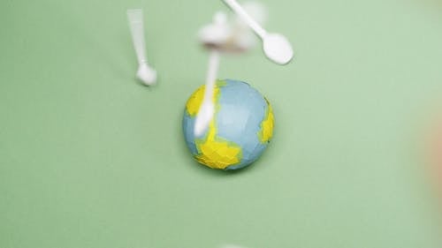 Plastic Wastes Falling on a Paper Earth Model 
