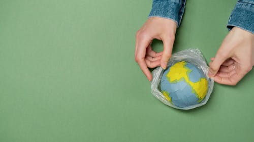 A Person Putting the Globe in a Plastic
