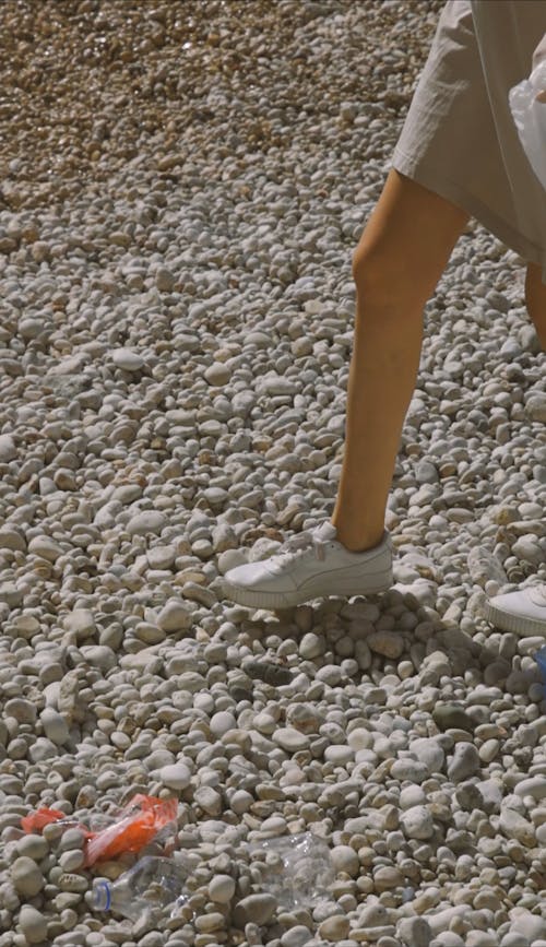 Woman Collecting Trash From The Stone Ground