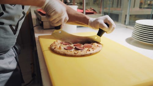 Man Slicing a Pizza