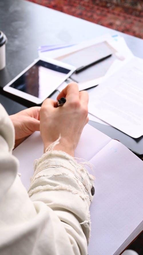 Person Writing On a Notebook