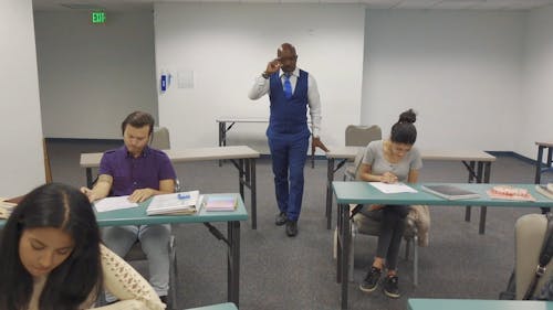 A Teacher Proctoring His Students During an Exam