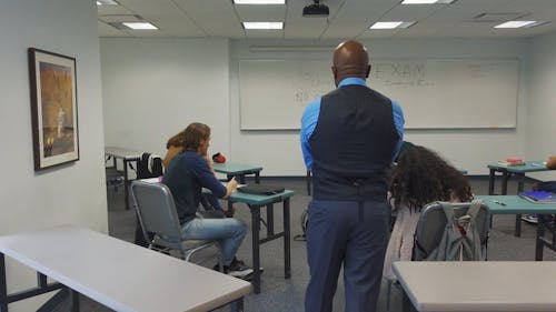 A Teacher Proctoring His Students During an Exam