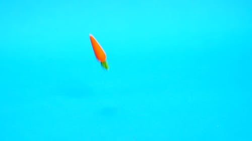 Falling Mini Carrots on a Blue Background
