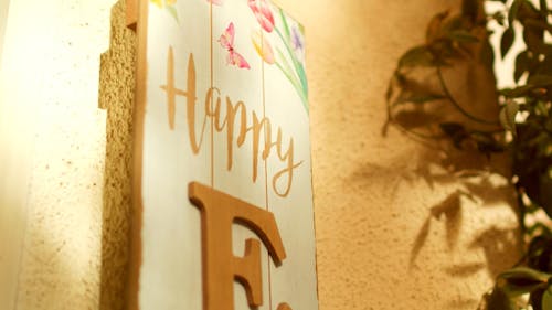 An Art in Wooden Board Illustration is on the Wall with a Message of Happy Easter.