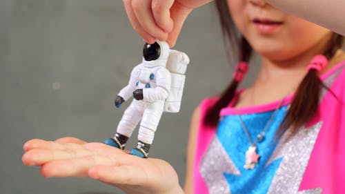 Girl Holding an Astronaut Miniature