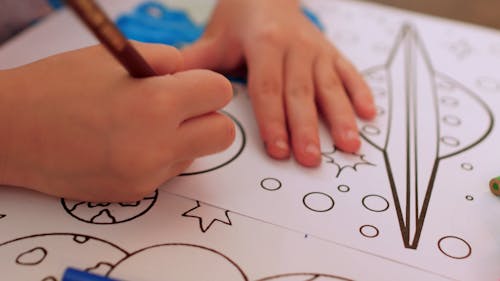 Kid Coloring a Drawing of Space