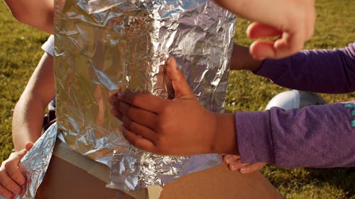Children Taping a Foil in a Box