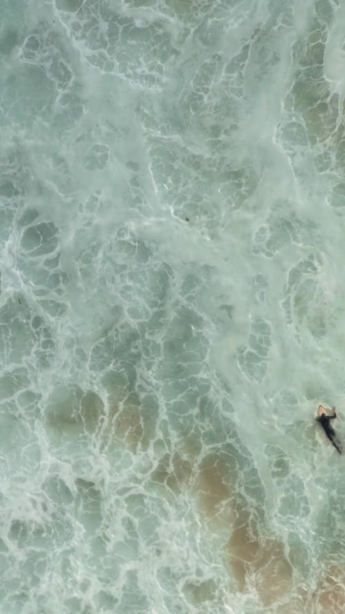 A Person Surfing and Getting Caught in the Waves
