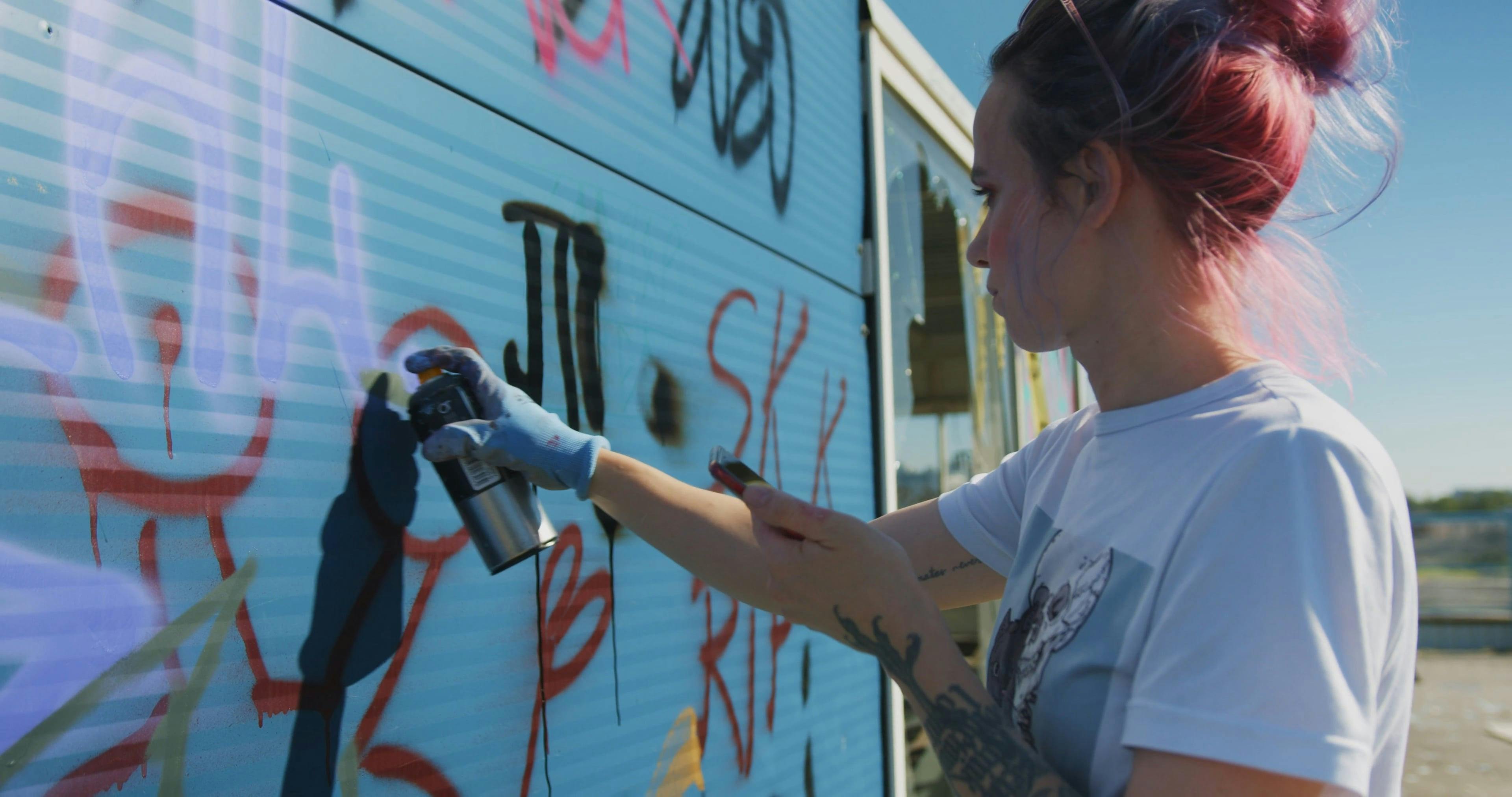 A Woman Spray Painting Graffiti On The Wall · Free Stock Video