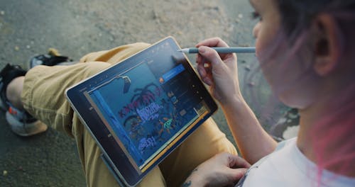 A Woman Sketching using a Stylus Pen on the Digital Tablet 