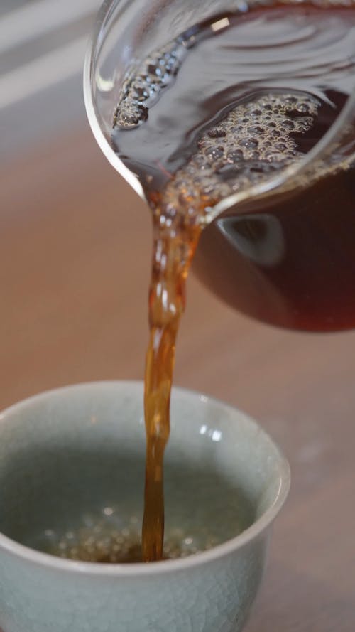 Person Pouring Tea into Cups