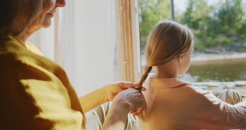 Grandmother Braiding the Hair of her Granddaughter