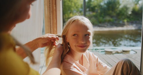 A Grandmother Fixing Her Granddaughter's Hair