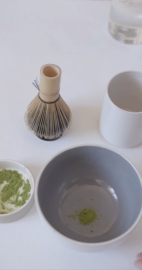 A Person Pouring Water on a Bowl With Matcha Powder