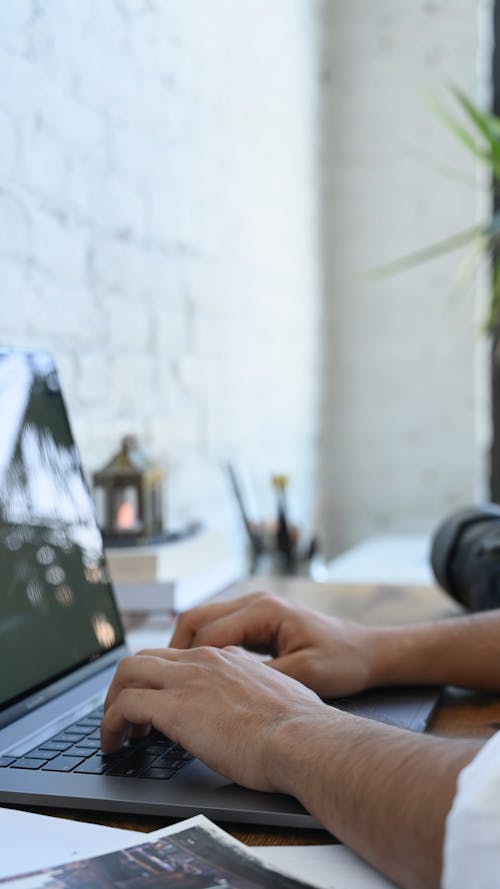 Side View Of Man Typing On Laptop