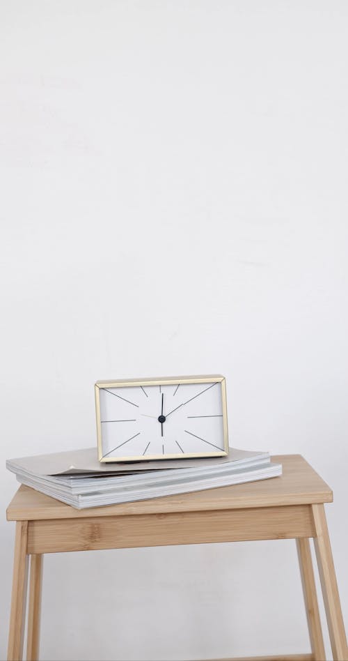 A Clock and Book on the Table