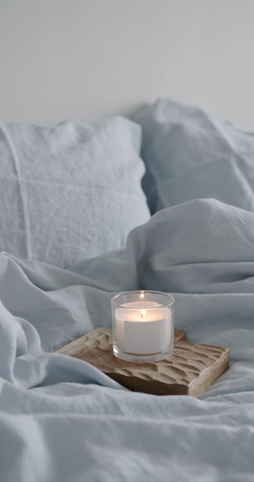 A Lighted Candle on Bed