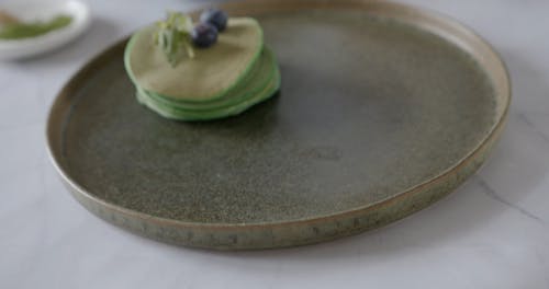 A Person Pouring Water into a Bowl of Matcha