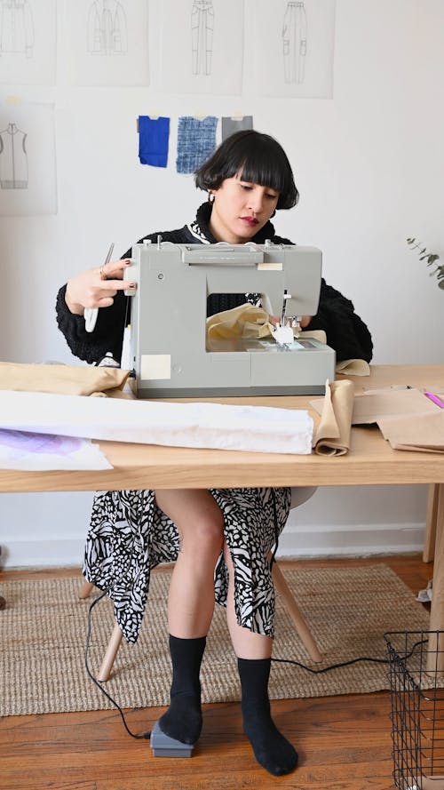 A Fashion Designer Adjusting The Sewing Machine