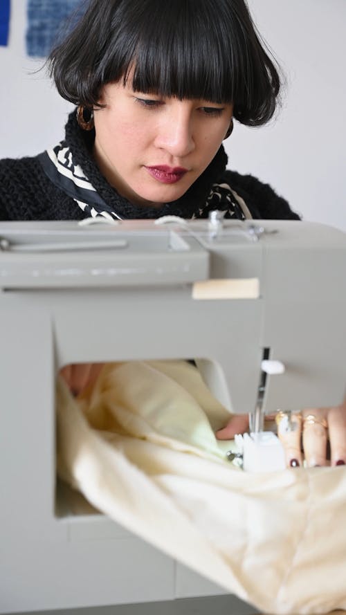 A Fashion Designer Sewing Clothes using a Sewing Machine