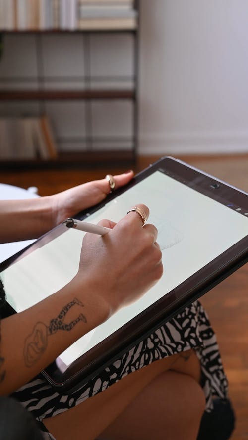 A Person Sketching on a Tablet while Sitting