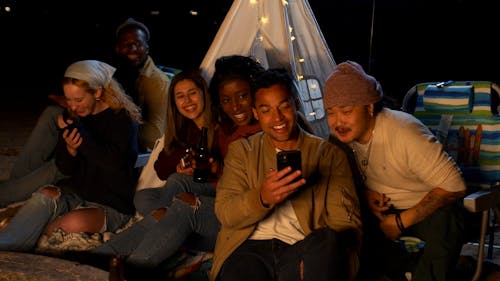 Man Holding His Phone Showing it to His Friends