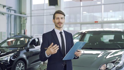 A Car Dealer Talking while Standing