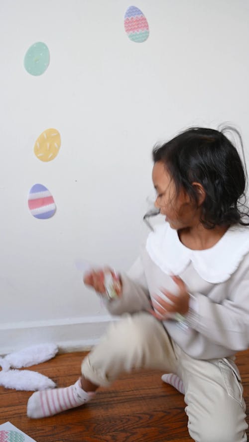 A Child Putting Egg Stickers on the Wall