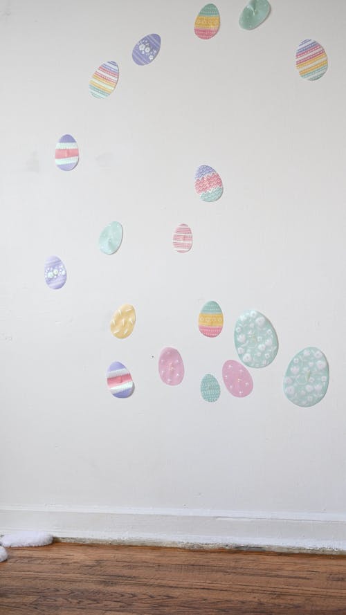 Little Girl Putting up Easter Egg Decorations on the Wall