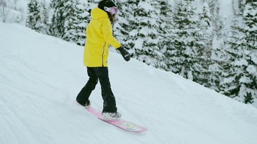 Female Snowboarder Riding Downhill