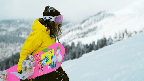 Female Snowboarder Walking Uphill