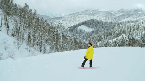 Woman in Yellow Jacket Snowboarding